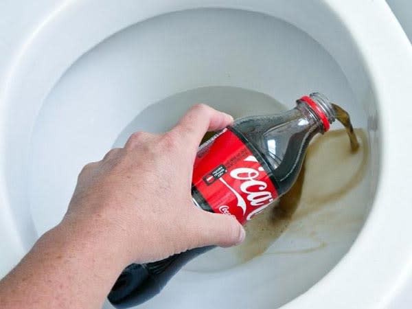 tay-cam-chai-coca-cola-do-nuoc-ngot-vao-bon-cau-1788927268.jpg