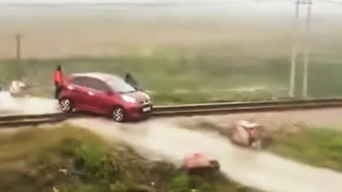 Người phụ nữ chạy ô tô mắc kẹt trên đường ray tàu hỏa bị phạt, lộ khoảnh khắc 21 giây vãy tàu thót tim
