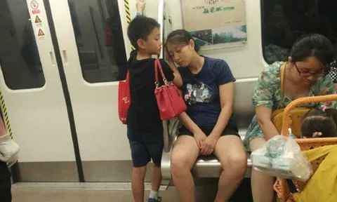 Bố làm shipper ngủ gật, bé trai giơ tờ giấy "Xin mọi người nói nhỏ" trên tàu điện, dân mạng: Đây mới là ông bố "giàu có"