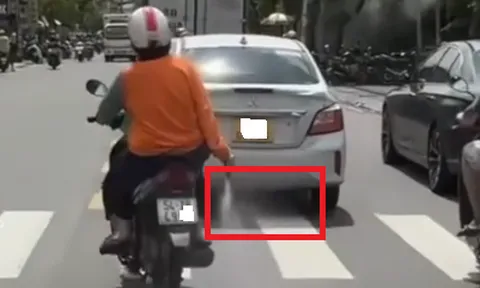 Người phụ nữ mặc áo màu cam liên tục rải bột "lạ" xuống đoạn đường dài ở TPHCM là chất gì?
