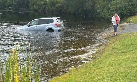 Mải đứng 'hóng drama', người phụ nữ sững sờ bất lực nhìn xế hộp 'bơi' giữa hồ nước như phim!