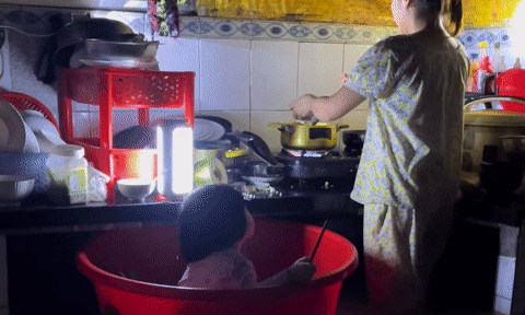 Cư dân mạng rưng rưng với khoảnh khắc em bé ngồi trong chậu, mẹ nấu cơm giữa biển nước lũ