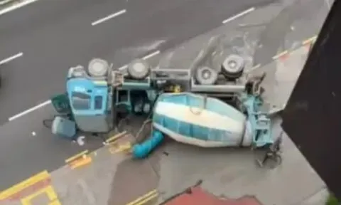 Xe bồn chở bê tông bất ngờ mất kiểm soát, lật ngang giữa đường khiến tài xế nhập viện, xi măng tràn khắp phố