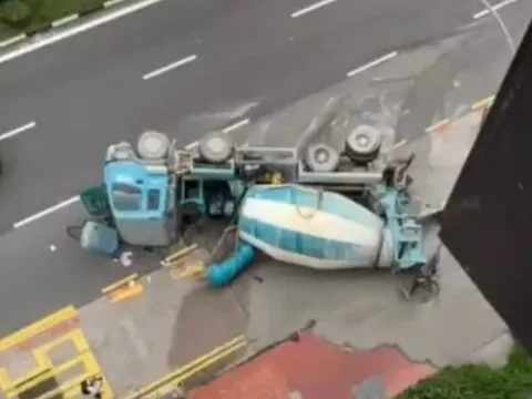 Xe bồn chở bê tông bất ngờ mất kiểm soát, lật ngang giữa đường khiến tài xế nhập viện, xi măng tràn khắp phố