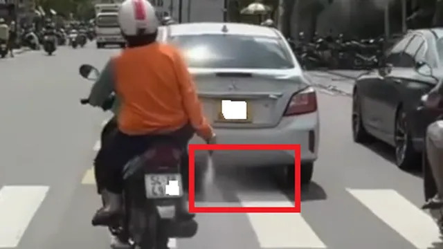 Người phụ nữ mặc áo màu cam liên tục rải bột "lạ" xuống đoạn đường dài ở TPHCM là chất gì?