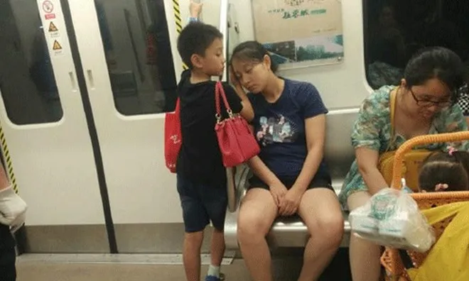 Bố làm shipper ngủ gật, bé trai giơ tờ giấy "Xin mọi người nói nhỏ" trên tàu điện, dân mạng: Đây mới là ông bố "giàu có"